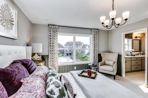 Wake up to soft light and calming vibes in this stylish owner's suite complete with plush carpet and large windows an ideal space to personalize and make entirely your own. (model photo)