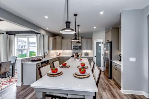The kitchen is anchored by a large quartz kitchen island. (model photo)