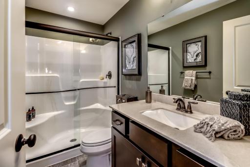 The lower level bath is stunning and spacious! It is ideal for servicing the lower level rec room and lower level bedroom. (model photo)