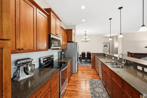 Open-concept view leading into an adjacent informal dining room
This galley-style layout with an expansive raised breakfast bar/island is ideal for entertaining or baking the holiday delights.