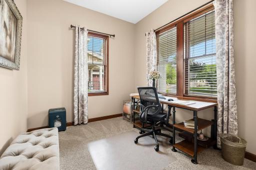 Soft natural light filters through wooden blinds, enhancing the room's warm ambiance, currently this space is used as an office/ craft room.