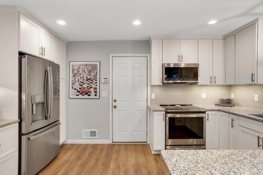 Stainless steel appliances pair beautifully with white cabinetry and granite countertops.