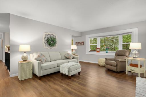 Natural light fills the spacious living room, complemented by updated flooring and neutral finishes.