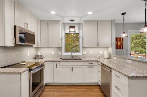Bright, functional kitchen with ample storage, modern finishes and a window overlooking the backyard.