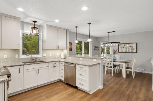 Beautifully updated kitchen with generous counter space, abundant cabinetry and views into the dining area.