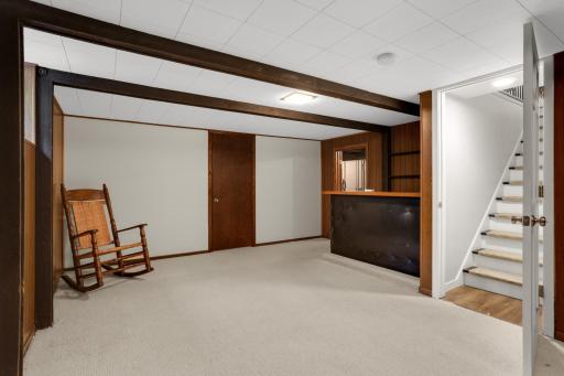 Finished lower level offers additional living and entertaining space with a built-in bar and exposed beam details.
