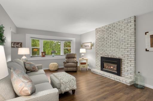 Bright and welcoming living room featuring a statement brick fireplace and large picture window.