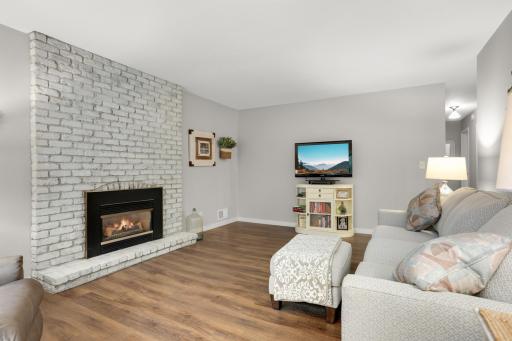 The painted brick fireplace creates a beautiful focal point in the living room.