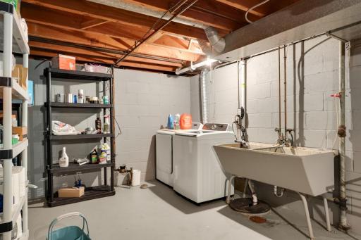 Lower-level laundry and utility area provides additional storage and functional workspace.