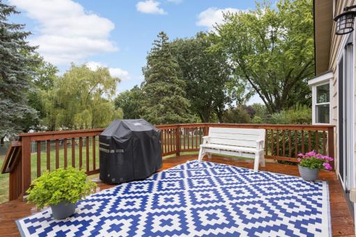 Enjoy outdoor dining, grilling, and relaxing on the spacious deck overlooking the backyard.