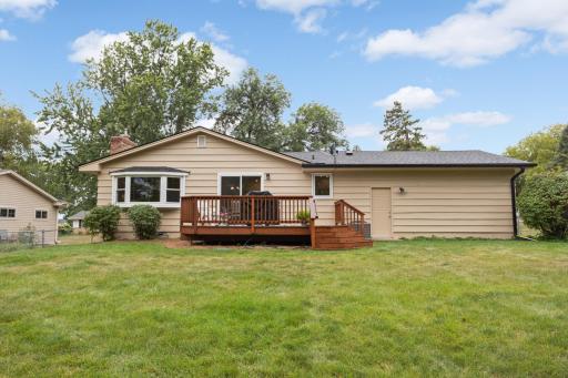 Rear exterior showcases the deck, expansive lawn, and generous backyard spaceâan extension of the home for outdoor living.