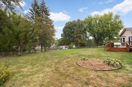 Large backyard surrounded by mature trees offers plenty of room to play, garden, entertain, or simply enjoy the outdoors.