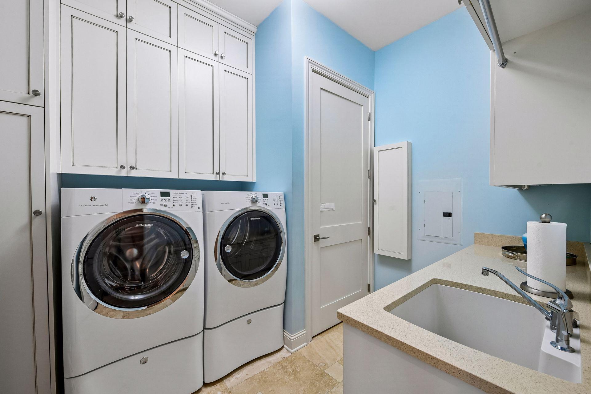 Main floor laundry room with sink and lots of storage space