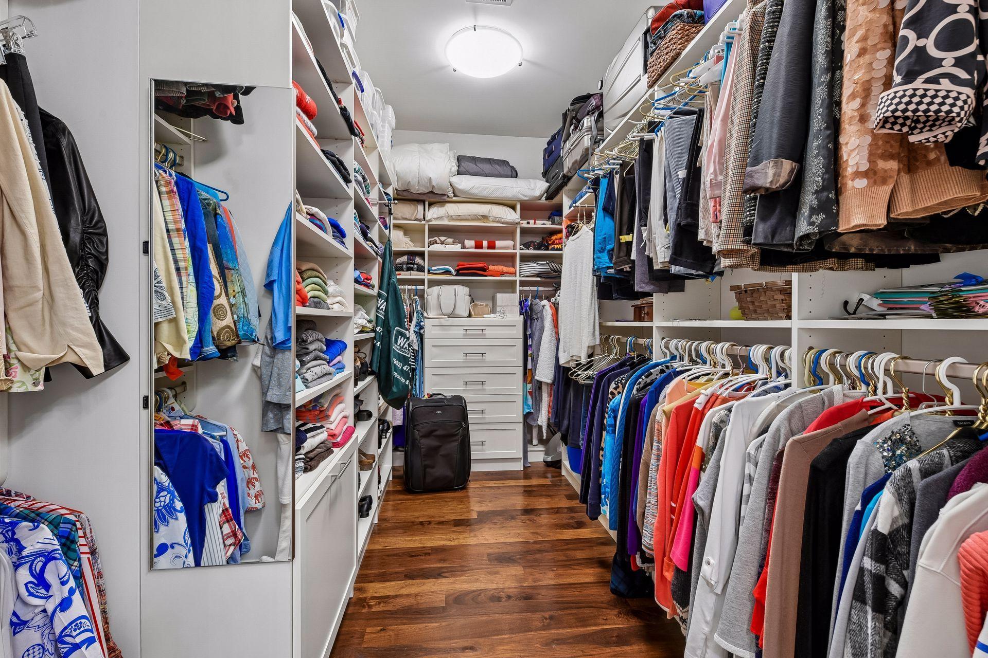 Primary bedroom walk-in closet with organizational components