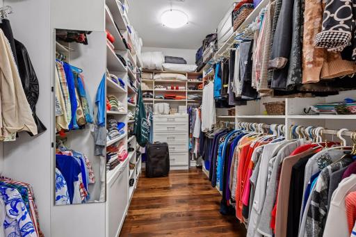 Primary bedroom walk-in closet with organizational components