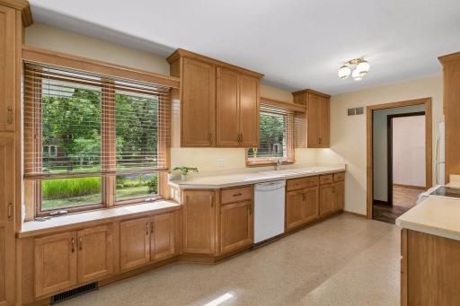 Large windows fill the informal dining area with natural light and offer lovely front yard views. Custom built-in cabinetry below provides extra storage and enhances the charm and functionality of the space.