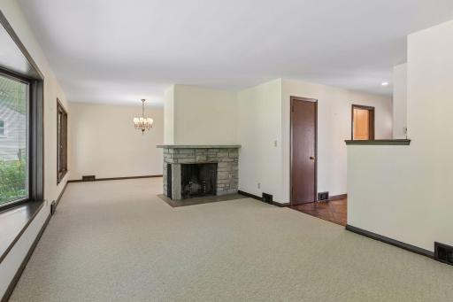 A beautiful wood-burning fireplace serves as the focal point, creating a natural separation between the living and formal dining spaces while adding warmth and timeless character.