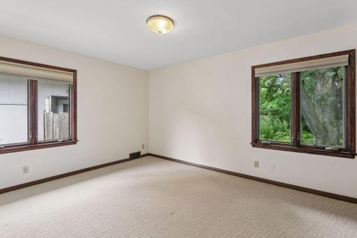 The spacious 14 x 11 primary bedroom offers peaceful backyard views, generous natural light, and the convenience of two large closets.