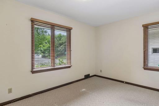 Located at the front of the home, the second main-floor bedroom measures 14' x 9' and offers a cozy space, large windows for natural light, and a convenient closet.