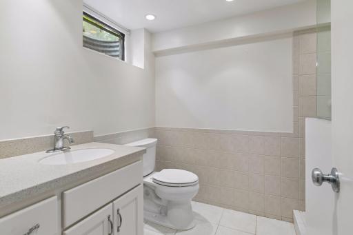 At the opposite end of the utility space from the laundry area is a remodeled ¾ bath with a tiled walk-in shower and updated vanity.