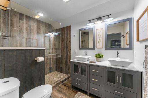 Stunning tile surround highlights the walk-in shower, complemented by a private en-suite complete with double sinks.