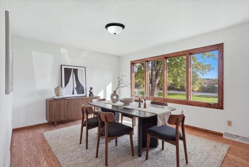 Bright formal dining room with warm wood flooring and beautiful views.