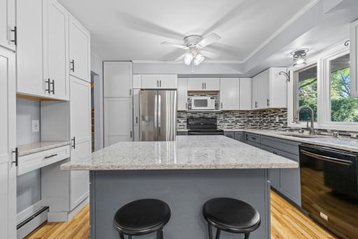 Updated in 2022, the kitchen features quartz countertops, Kraft cabinetry, a custom island, and smart pull-out storage throughout