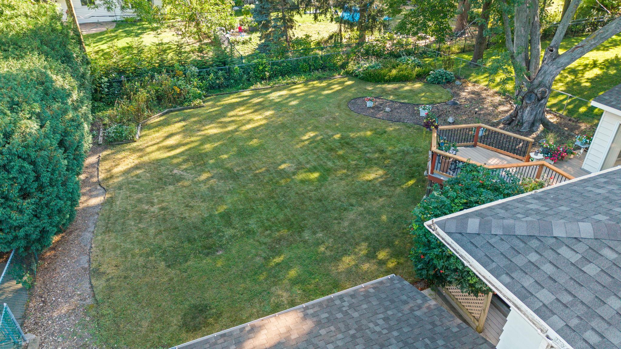 Generous backyard with a level lawn and thoughtful landscaping that adds beauty and privacy