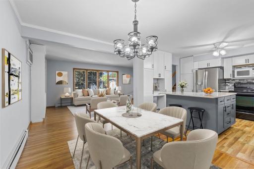 Open-concept living connects the living room, kitchen, dining area, and four-season porch for an easy, spacious flow-Virtually staged