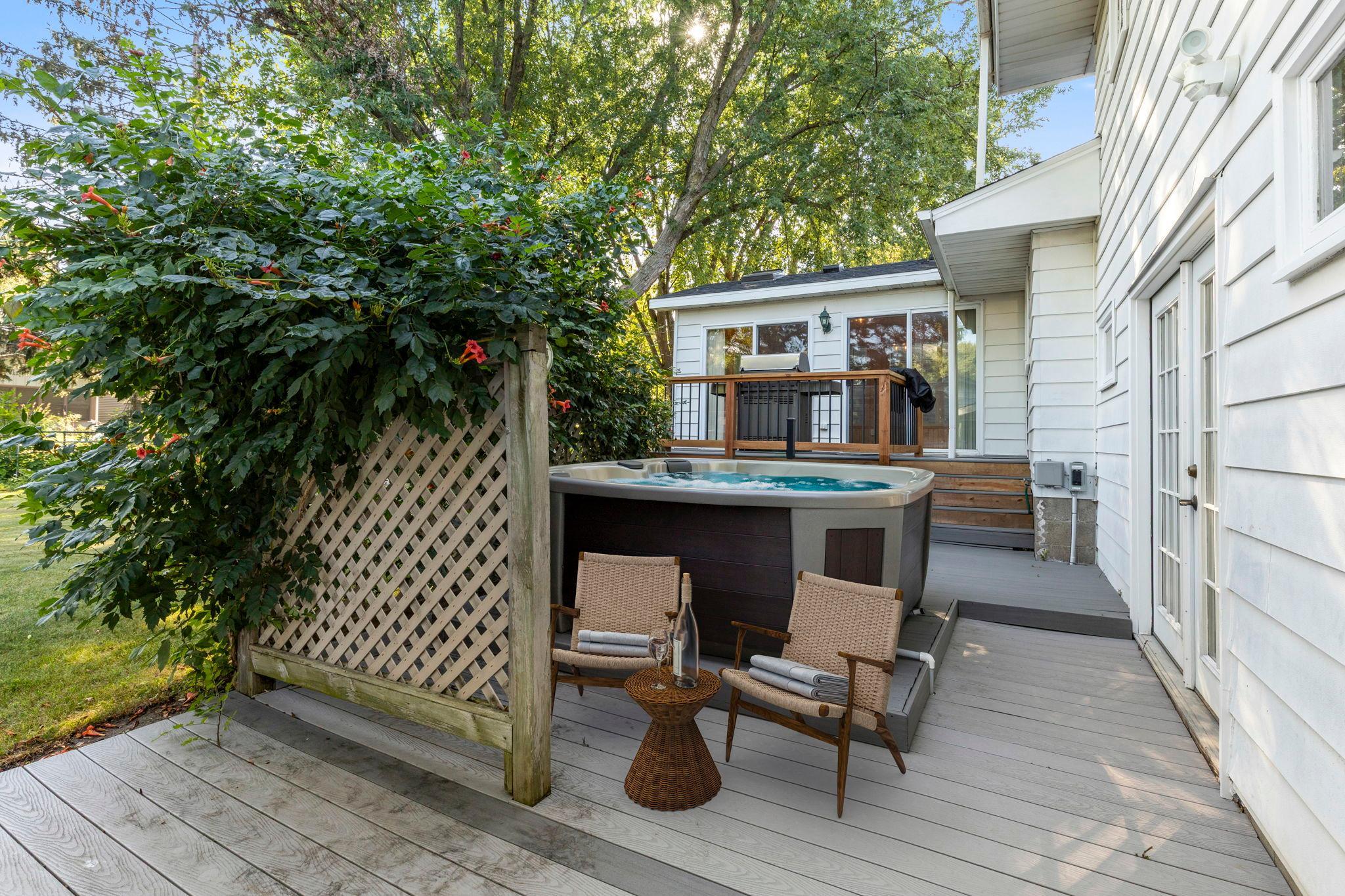 Hot tub secluded by fence with beautiful Trumpet Vine-Virtually staged