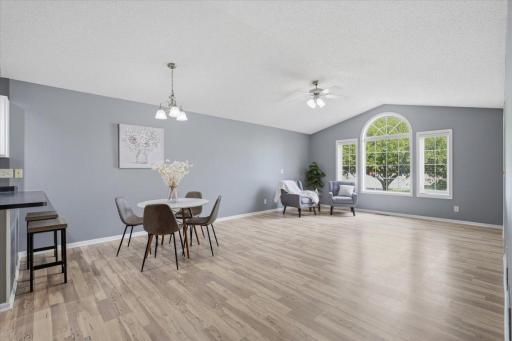 Large windows, a vaulted ceiling and light flooring give this living and dining area a bright, open feel with plenty of room to relax and entertain.