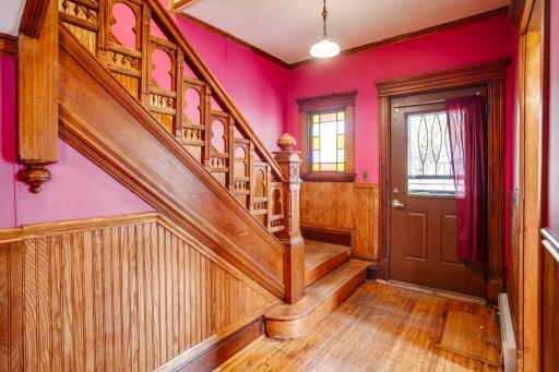 Hallway looking toward front door with beautiful stained glass window.