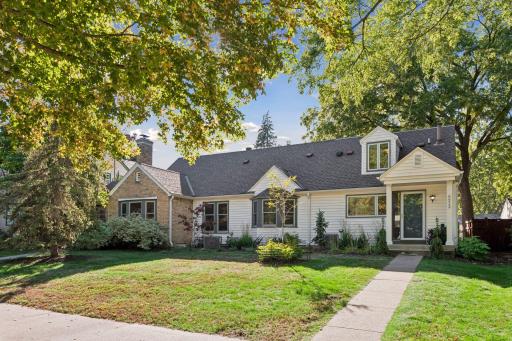 Front Exterior - Front view highlights the homeâs broad footprint, mature trees, landscaped yard, dormer window, bay window, and welcoming covered entry.