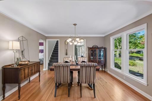 Formal Dining Room - A spacious dining room with hardwood floors, large windows, and plenty of room for a full dining set. Nearby openings provide easy access to the kitchen, stairs, and adjoining bedrooms and full bath.