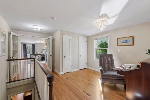 Upper-Level Landing - Hardwood floors continue through this spacious upper landing, offering room for a desk or sitting area with easy access to the surrounding bedrooms.