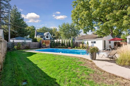 Backyard & Pool - Private fenced backyard features a large in-ground swimming pool surrounded by patio space, mature landscaping, lawn, and a detached garage.