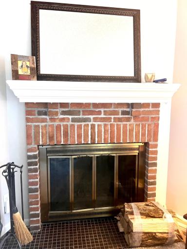 Woodburning fireplace in the living room - mirror above the fireplace comes with the home.jpeg