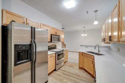 The main level offers a warm and welcoming living room with high ceilings, a beautifully updated kitchen with stainless steel appliances and brand-NEW quartz countertops.