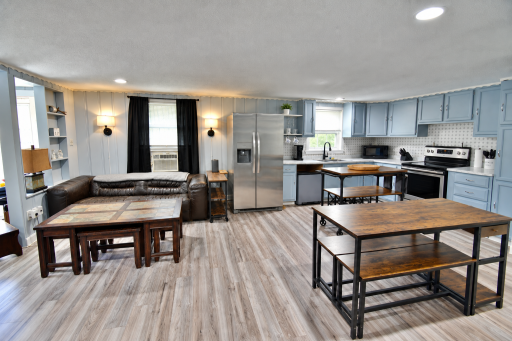Open-concept kitchen, dining & living area (AI used to remove personal items only)