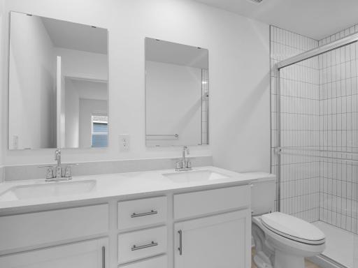 The private bathroom includes a stylish vanity and a glass-enclosed shower for a spa-like atmosphere