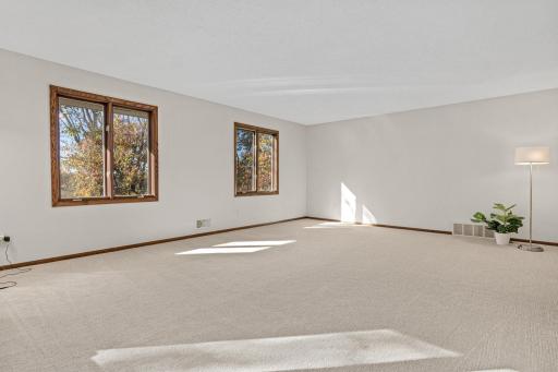Spacious and inviting living room with wonderful natural light. New carpet and paint.