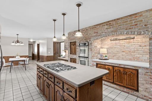 Large center island is perfect for buffet style entertaining, meanwhile the brick nook is a great coffee or happy hour station.