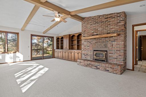 The main-level family room offers a wood burning fireplace, beautiful built-ins and access to the large deck.