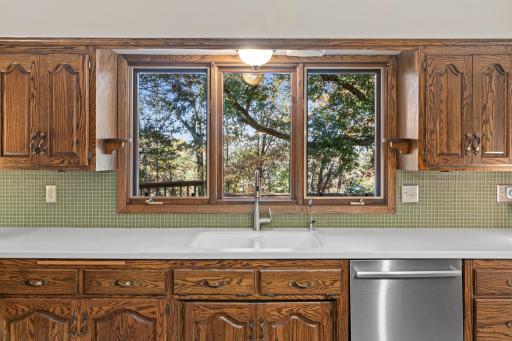 Large kitchen windows provide views of the private backyard and Deep Lake in the distance.