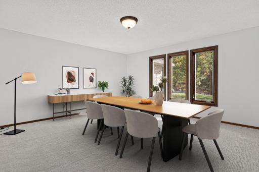 Main floor formal dining room with beautiful views to the front yard. Visually staged.