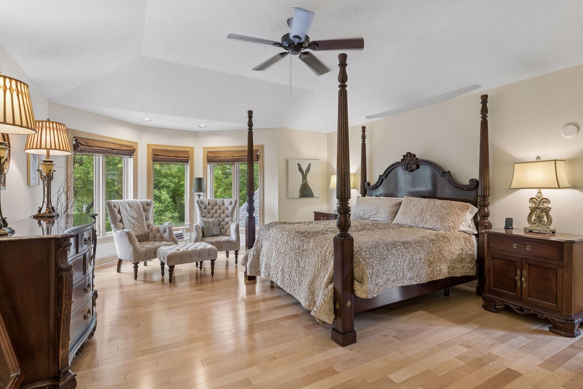 Valuted primary suite with wood flooring