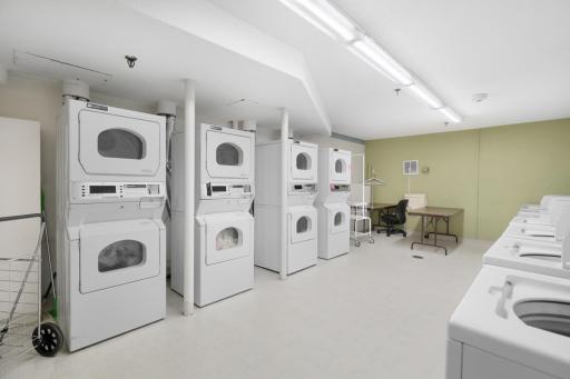 Convenient on-site community laundry room featuring multiple washers and dryers, providing residents with easy access to laundry facilities within the building.