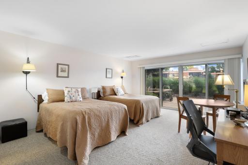 Guest Suite: Convenient building guest suite available for residentsâ visitors, offering a comfortable private space with sleeping accommodations, dining/work area, and direct access to an outdoor patio.