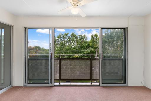 Enjoy a private enclosed balcony with large windows, a ceiling fan, and peaceful treetop viewsâan inviting space to relax and enjoy the outdoors from the comfort of home.