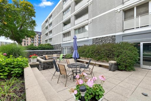 Private courtyard patio with tables, seating and seasonal gardens, a relaxing spot to enjoy the outdoors.